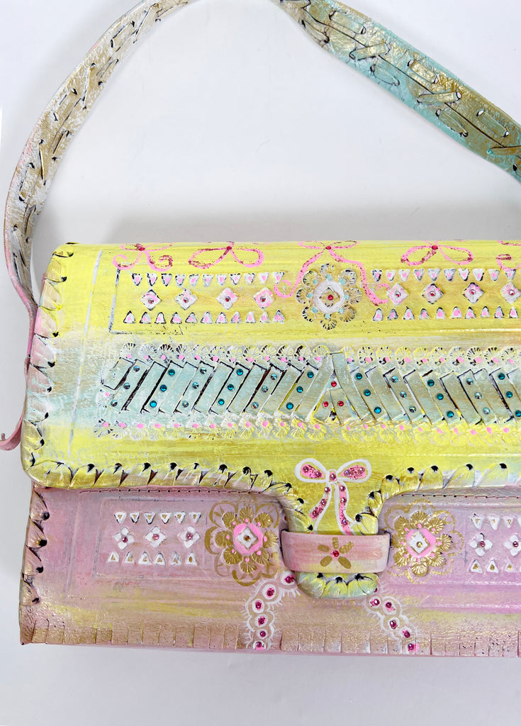 Beautiful hand painted, up-cycled leather handbag in pastel colors with bows by Mer Rose Atelier.