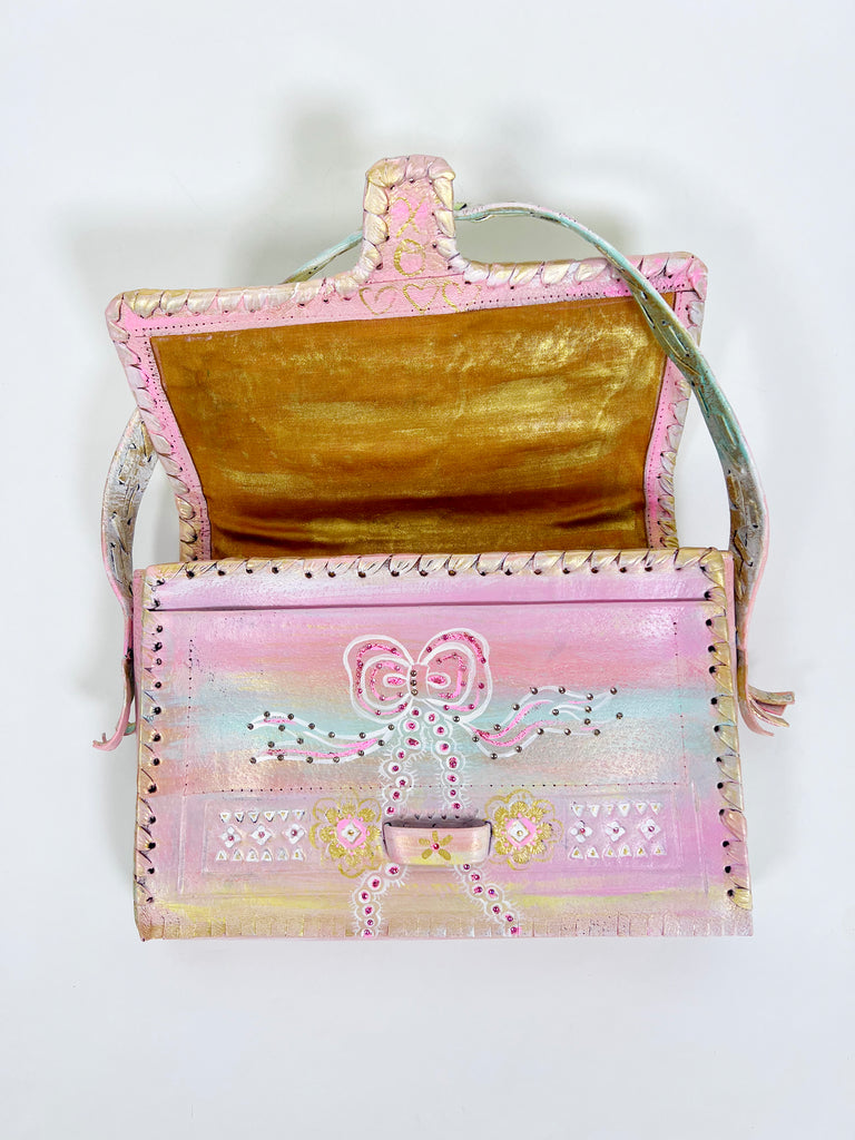 Beautiful hand painted, up-cycled leather handbag in pastel colors with bows by Mer Rose Atelier.