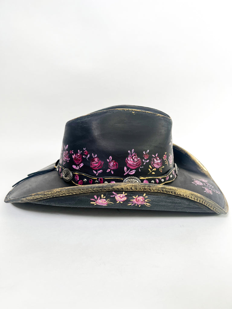 Stand out with a custom painted hat. This beauty is covered with elegant, whimsical hand painted, one-of-a-kind roses, buds and metallic gold details.
